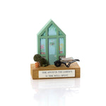 A wooden decorative block featuring a miniature greenhouse with a pair of wellies, a potted tree, and a wheelbarrow on top, with a plaque that says 'Time spent in the garden is time well spent'. 02
