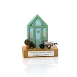 A wooden decorative block featuring a miniature greenhouse with a pair of wellies, a potted tree, and a wheelbarrow on top, with a plaque that says 'Time spent in the garden is time well spent'. 02