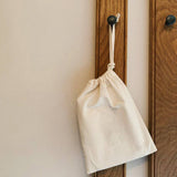 A child is playing with a set of white animal-themed alphabet flashcards with a letter on each card, featuring illustrations of various animals such as a giraffe, a zebra, a deer, and a bear.