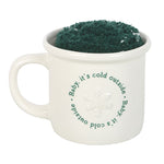 White mug with green text and green powder inside on a white background