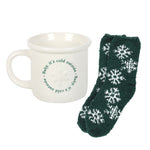 White mug with text and green socks with snowflake pattern on a white background
