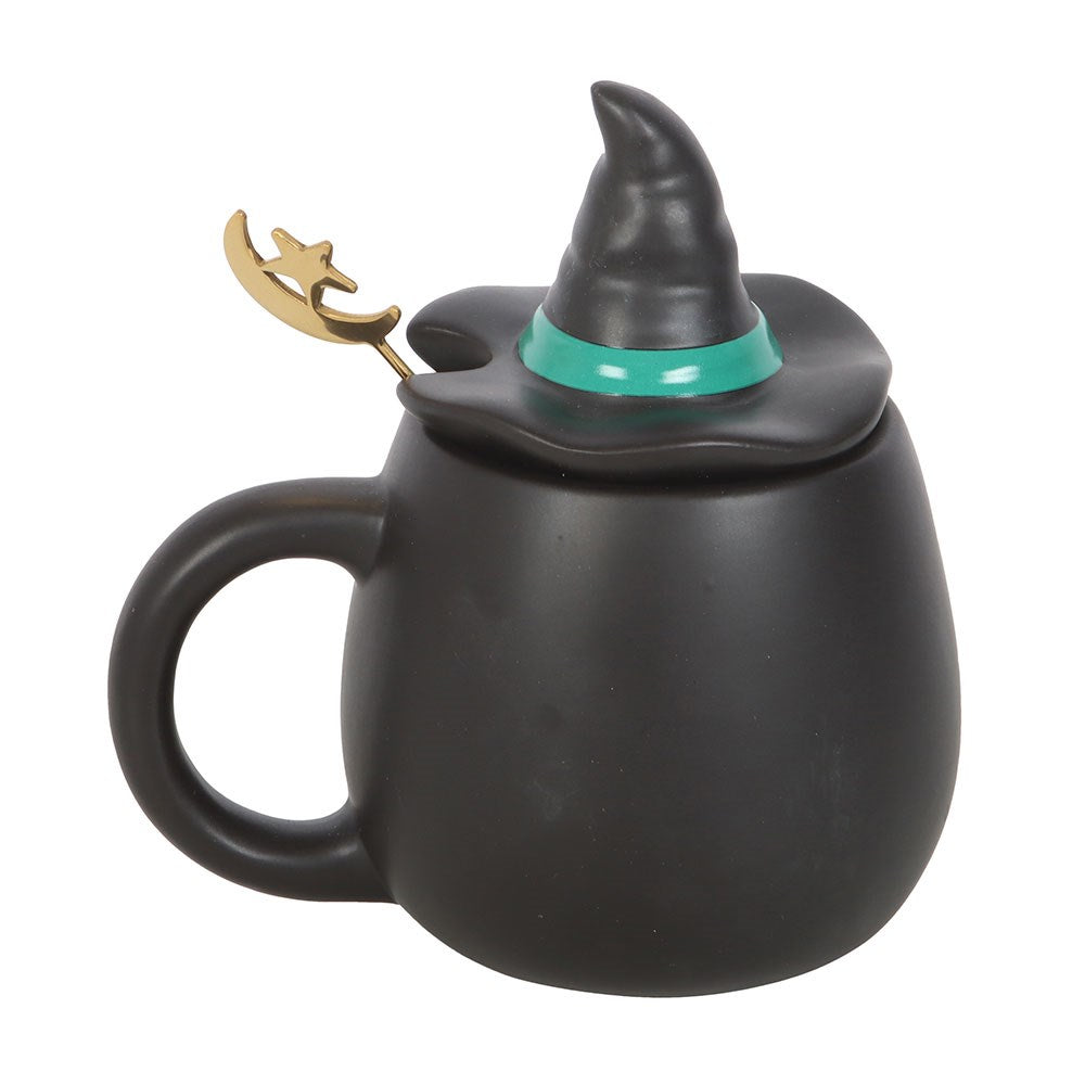 Black mug with witch hat lid and spoon rest on a white background