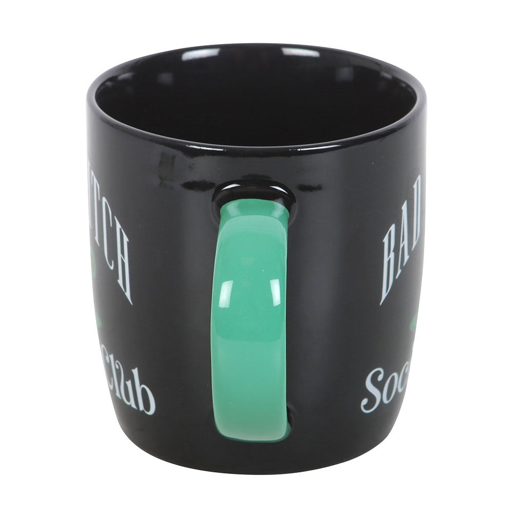 Black mug with a green handle on a white background