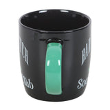 Black mug with a green handle on a white background