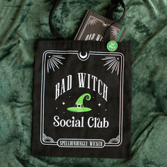 Black tote bag with 'Bad Witch Social Club' design on a green textured background