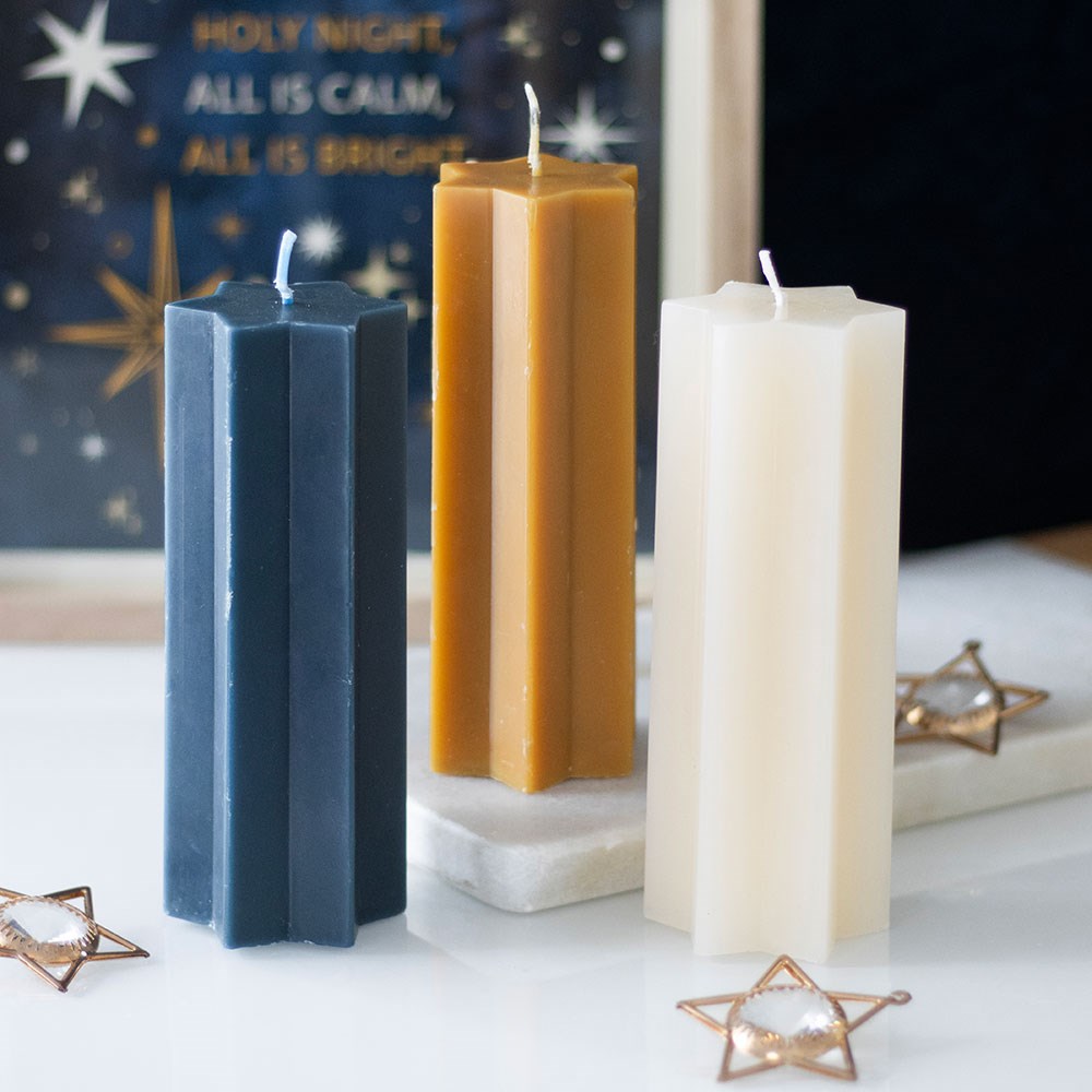 Three hexagonal candles in blue, gold, and white on a decorative background with stars and text.