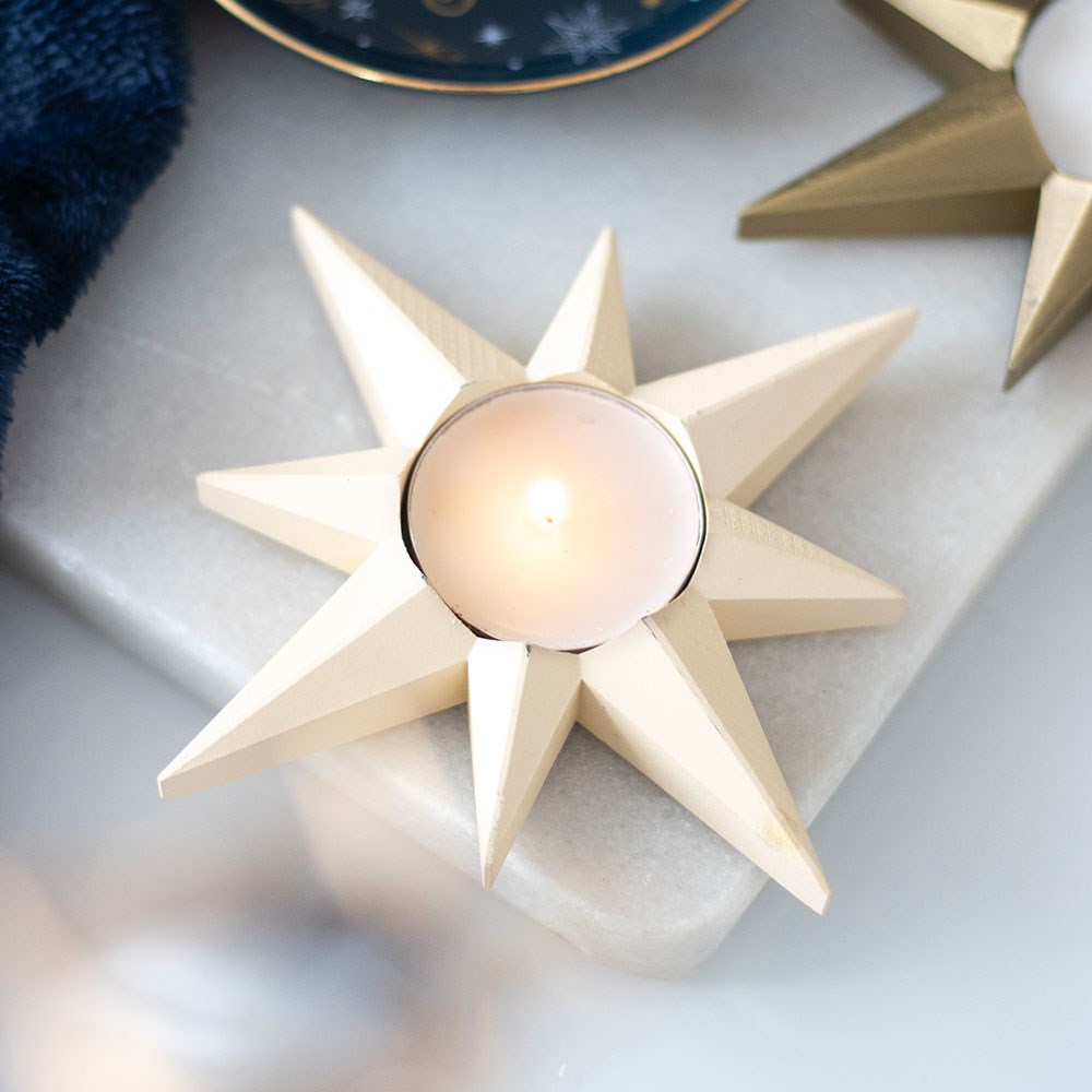 Star-shaped candle holder with a candle on a marble surface