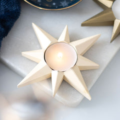 Star-shaped candle holder with a candle on a marble surface