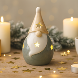 Decorative gnome with star design on a table with candles and Christmas decorations.
