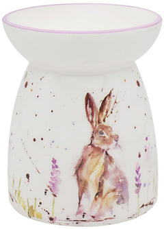 A ceramic wax burner with a hand-painted design featuring a hare, lavender flowers, and a purple field.