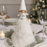 Decorative tall fluffy Angel figure on a table with Christmas decorations