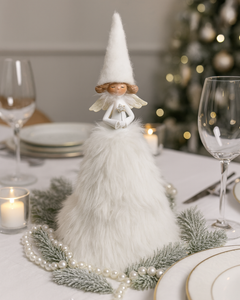 Decorative tall fluffy Angel figure on a table with Christmas decorations