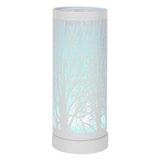 An electric wax melt warmer with a white tree silhouette design, placed on a table with a plant and a decorative oil lamp in the background, with text 'LED Colour Changing'.