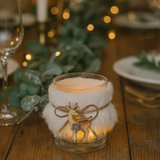 Decorative candle holder with a deer design on a wooden table with blurred lights in the background