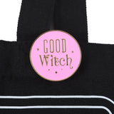 Pink 'Good Witch' enamel pin on a black bag