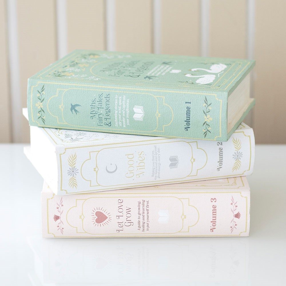 Stack of decorative books with pastel covers on a white surface
