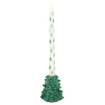 Decorative candle with a green tree-shaped holder on a white background