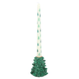 Decorative candle with a green tree-shaped holder on a white background