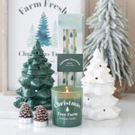 Decorative candles with Christmas tree design on a white surface.
