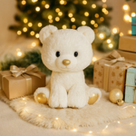 Glitzy Tots Polar Bear sat on a fluffy rug in front of a Christmas tree surrounded by presents 