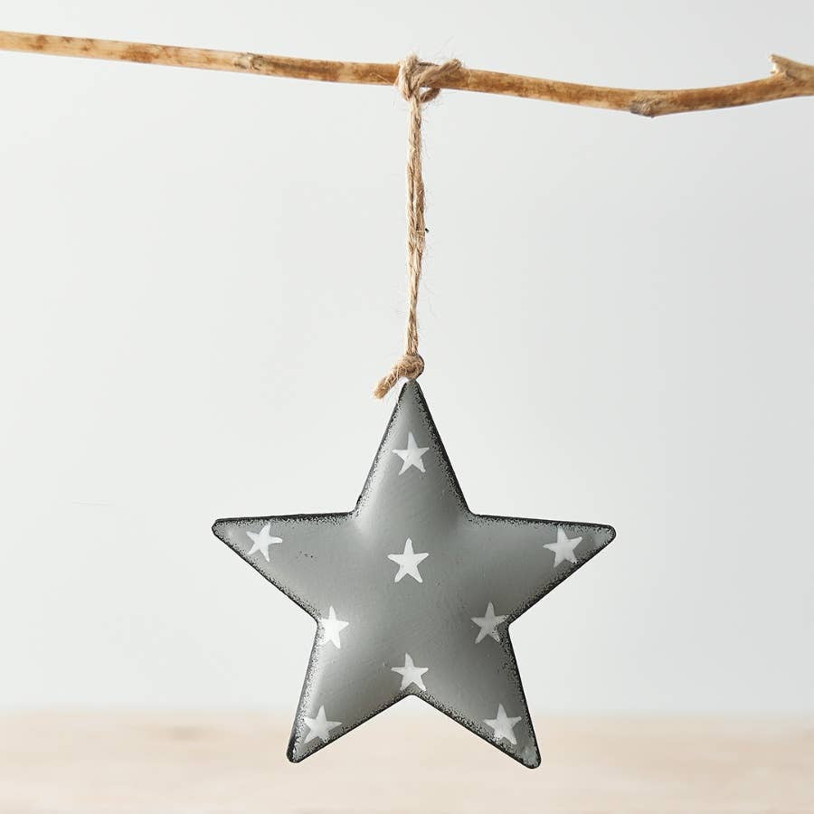 A grey metal hanging star with a white starry print, displayed against a white background.