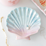 Shell-shaped jewelry dish with a necklace on a light background