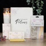 A box labeled 'Magic Love Spell in a Box' with illustrations of a heart and a spellbook. The box contains three pink spell candles.