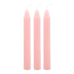 A box labeled 'Magic Love Spell in a Box' with illustrations of a heart and a spellbook. The box contains three pink spell candles.