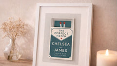 Framed print with 'The Perfect Match' text on a wooden surface with a candle and vase in the background.