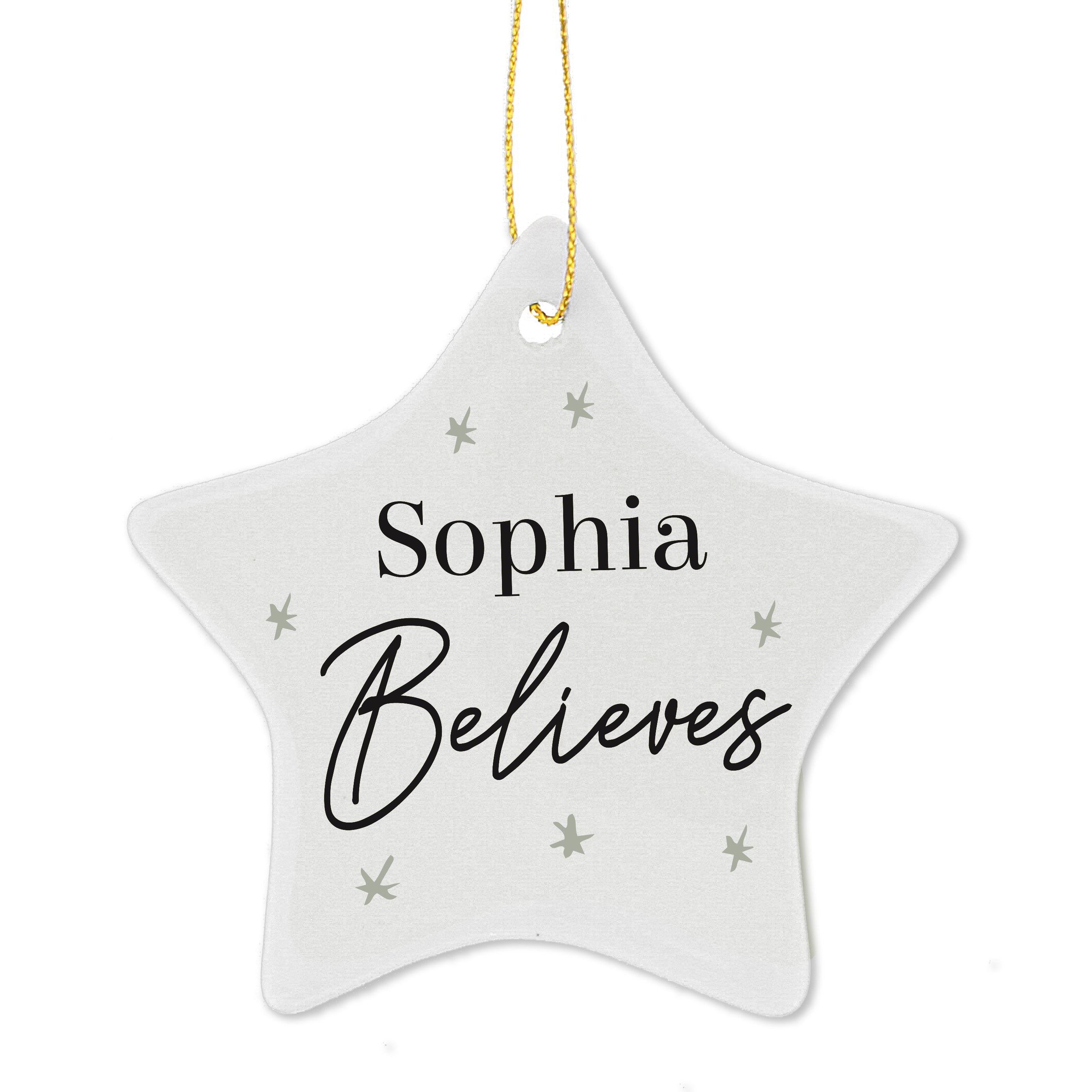 A white ceramic star-shaped decoration with the word 'ELSIE BELIEVES' printed in black, hanging from a golden ribbon on a green pine branch. 02