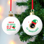Two round Christmas ornaments with a green and red colour scheme. The first ornament has the text 'Anna is under ELF surveillance' and the second one says 'Elf surveillance'. 01