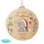 A round wooden decoration featuring an illustration of a teddy bear with a Santa hat, surrounded by Christmas-themed elements like stars, berries, and the text 'My First Christmas'. 03