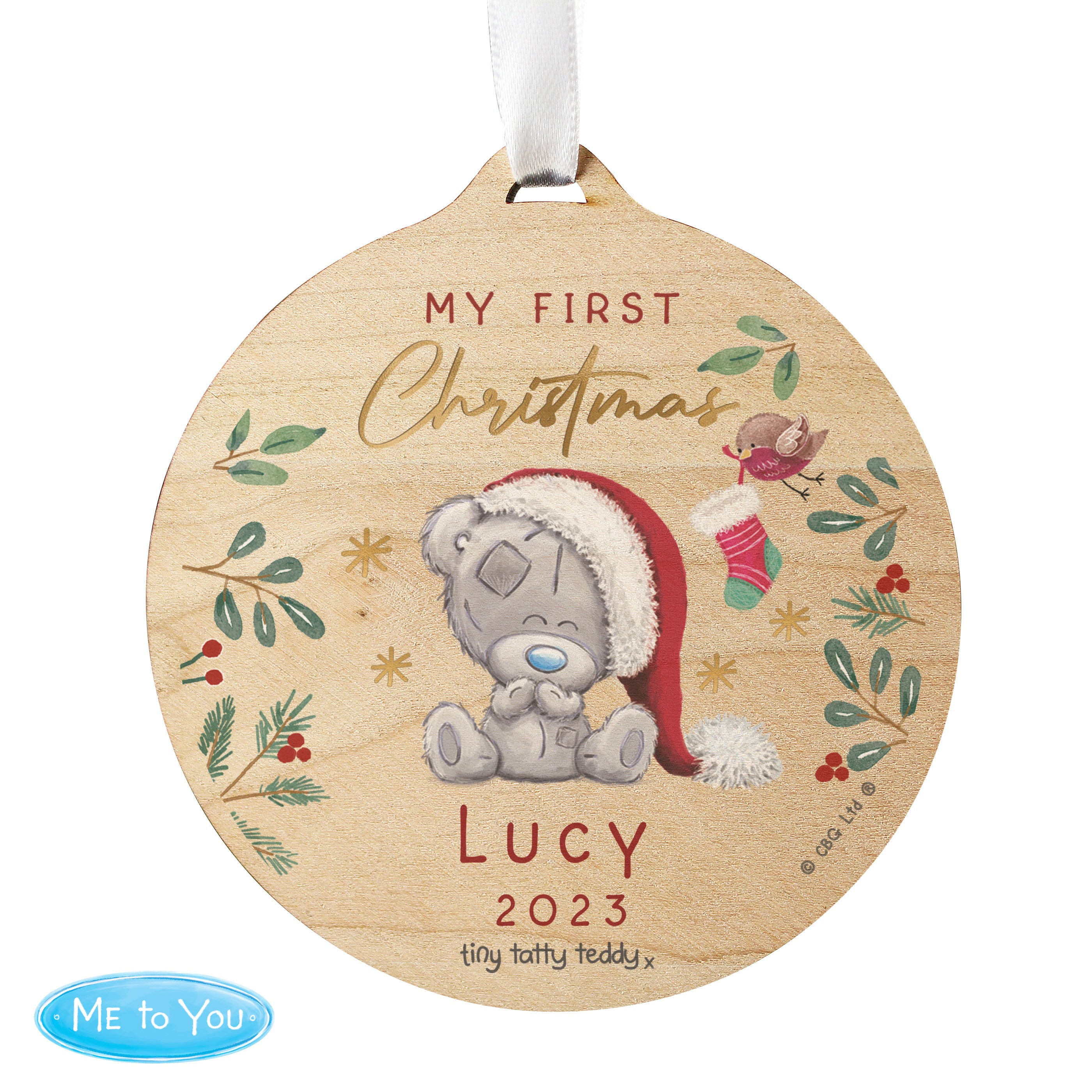 A round wooden decoration featuring an illustration of a teddy bear with a Santa hat, surrounded by Christmas-themed elements like stars, berries, and the text 'My First Christmas'. 03