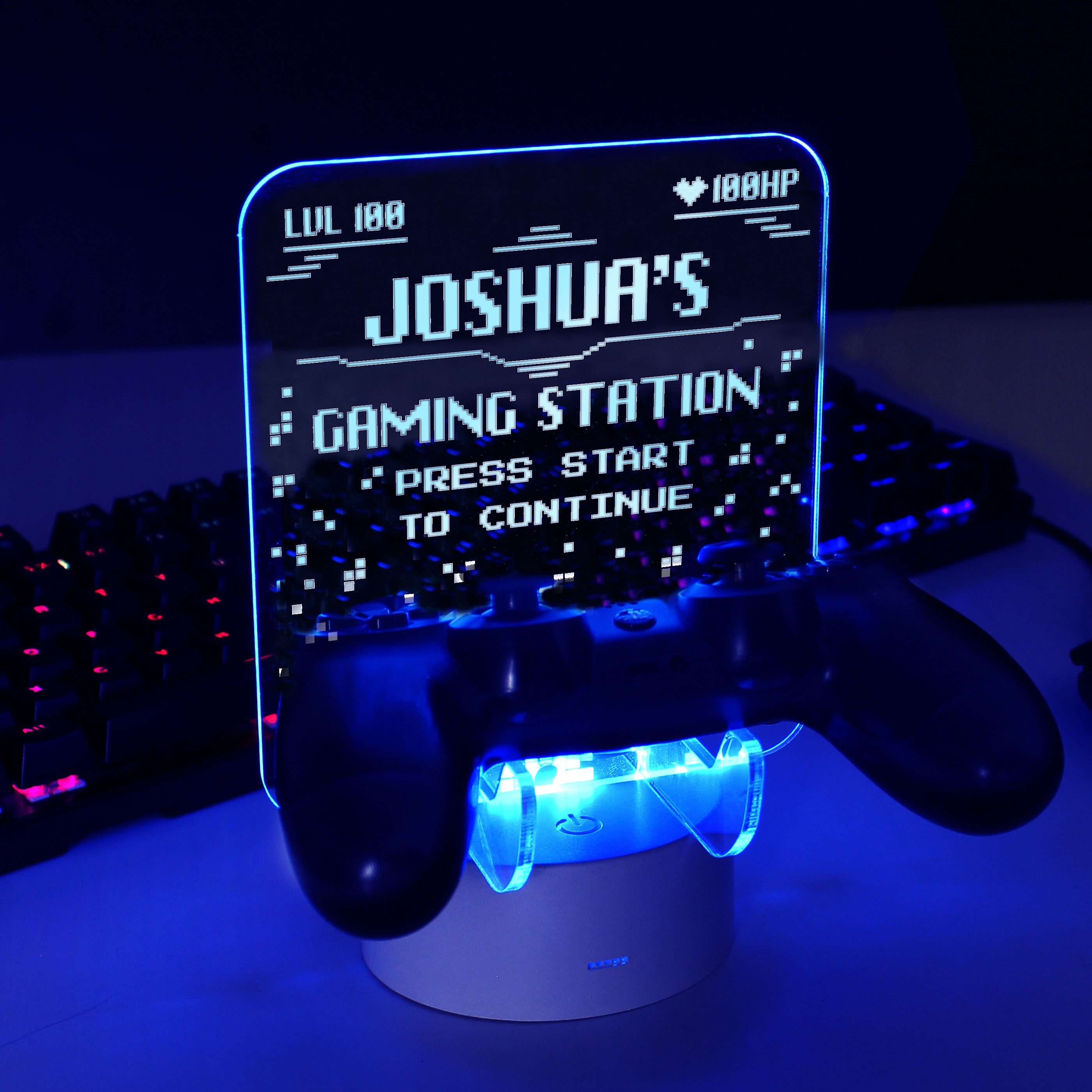 Personalised gaming controller holder with LED colour changing light, displaying a name and gaming-related phrases on a illuminated panel.