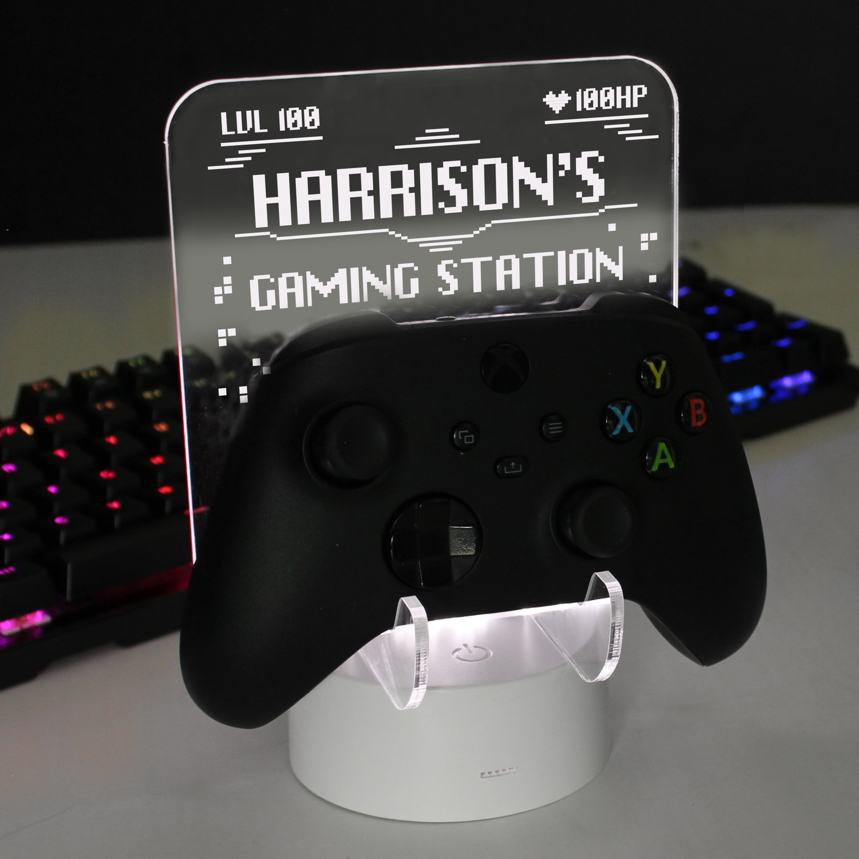 Personalised gaming controller holder with LED colour changing light, displaying a name and gaming-related phrases on a illuminated panel.
