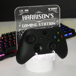 Personalised gaming controller holder with LED colour changing light, displaying a name and gaming-related phrases on a illuminated panel.