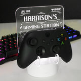 Personalised gaming controller holder with LED colour changing light, displaying a name and gaming-related phrases on a illuminated panel.