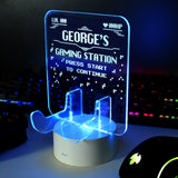Personalised gaming controller holder with LED colour changing light, displaying a name and gaming-related phrases on a illuminated panel.