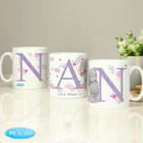 Three ceramic mugs with 'Nan' written on each, featuring floral and animal designs, placed on a table with a 'Me To You' logo in the corner.