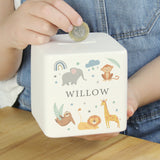A white ceramic square money box with a personalised name 'Arthur' and a jungle animal theme, featuring illustrations of an elephant, giraffe, monkey, lion, and zebra.