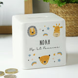 A white ceramic square money box with a personalised inscription and decorated with safari animal illustrations, including a lion and a giraffe, and the name 'Noah'.