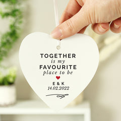 Hand holding a personalised hanging sign with the words 'together is my favourite place to be' 