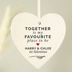 Hand holding a personalised hanging sign with the words 'together is my favourite place to be' 