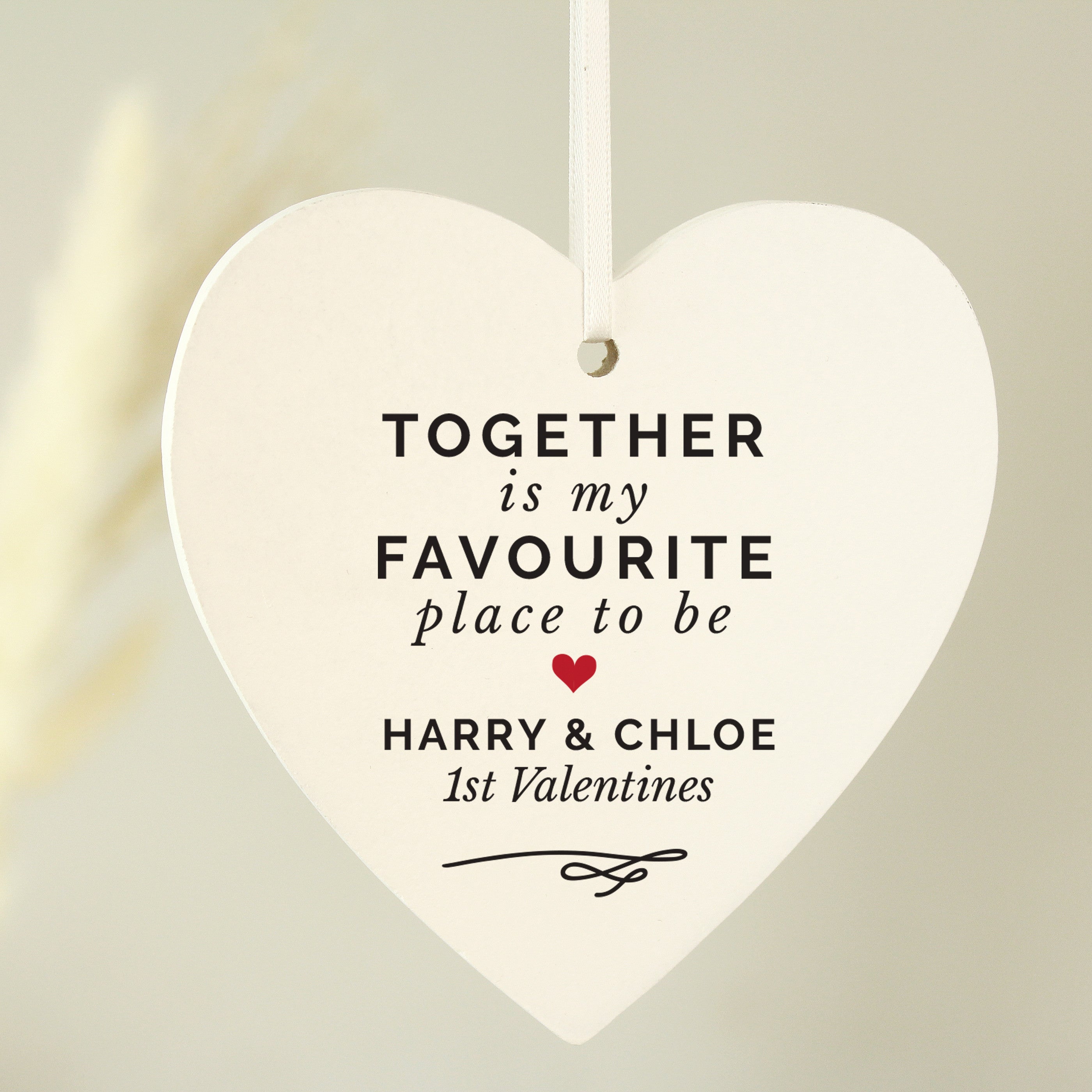 Hand holding a personalised hanging sign with the words 'together is my favourite place to be' 