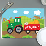 A colourful personalised placemat featuring a tractor design with the name 'Arthur' printed on it, placed on a table with a fork and knife on either side.