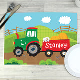 A colourful personalised placemat featuring a tractor design with the name 'Arthur' printed on it, placed on a table with a fork and knife on either side.