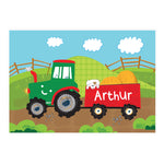 A colourful personalised placemat featuring a tractor design with the name 'Arthur' printed on it, placed on a table with a fork and knife on either side.