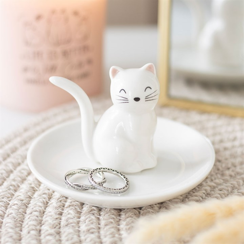 Cat-shaped ceramic ring holder with rings on a textured surface