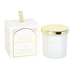 Scented candle with gold lid and packaging labeled 'The Story of Serenity' on a white background