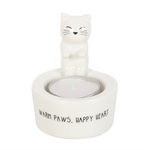 Ceramic cat-shaped candle holder with 'Warm Paws, Happy Heart' text on a white background